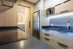 una cucina con frigorifero e armadietti in acciaio inossidabile di Apto Super Moderno e Central a Florianópolis Altre 28 foto