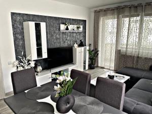 布加勒斯特PRESTIGE PALACE BUCHAREST的配有电视、桌椅的客厅