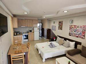 Una sala de estar y una cocina con una cama y una mesa. en Paralax Hotel, en Varna