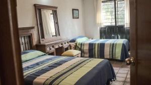 a room with two beds and a mirror at Casa Aply in San Andrés Huayapan