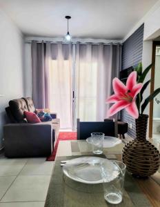 a living room with a couch and a table at BEM no CeNtRo, cozinha completa, varanda e garagem in Poços de Caldas