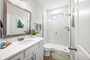 a bathroom with a sink and a toilet and a mirror at Adam's Downtown Retreat with 2 Rooftop Patios (1012/1014 Franklin) in Clarksville