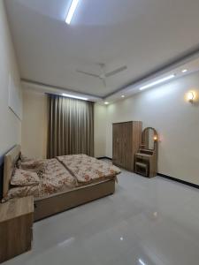 une chambre avec un lit, une coiffeuse et un miroir dans l'établissement Villa Modern صلاله صحنوت, à Arzat