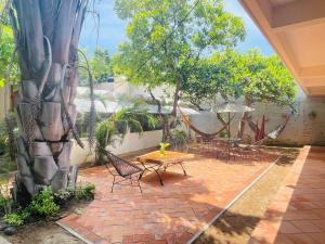 埃斯孔迪多港Casa Sixta a 7min del aeropuerto internacional PMX y 2 cuadras terminal autob ADO的有桌子、椅子和一棵树的露台