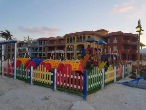 un parque infantil frente a un edificio con una valla en PORTO MATROUH chalet families only, en Marsa Matruh