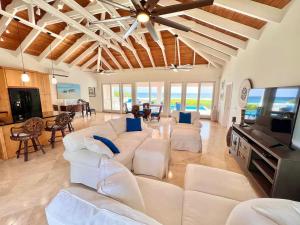 Una sala de estar con sofás blancos y un televisor. en Toes in the Sand Beach House, en Christiansted