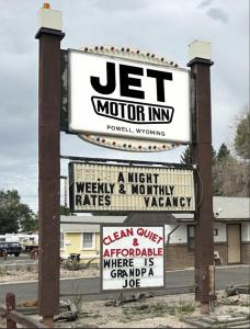 a sign for a motor inn with many signs at JET Motor Inn in Powell