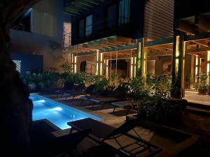 a building with a swimming pool with tables and chairs at KINEKI La Punta - Casa Karen in Brisas de Zicatela