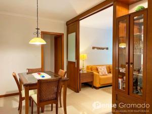 a dining room and living room with a table and chairs at Apartamento 1 dormitório a 150m do Mini Mundo in Gramado +15 photos