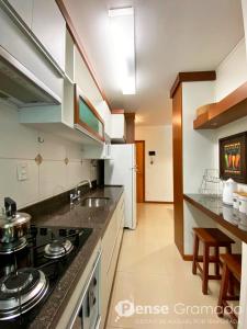 a kitchen with a sink and a stove top oven at Apartamento 1 dormitório a 150m do Mini Mundo in Gramado