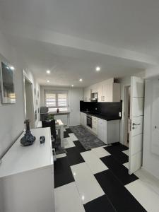 a kitchen with a black and white checkered floor at Ferienwohnung Gani in Kißlegg +13 photos