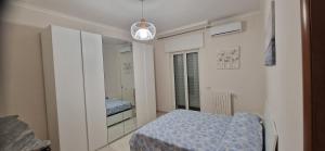 Un dormitorio pequeño con una cama y un espejo. en Casa Vacanze Profumo di Mare, en Bari