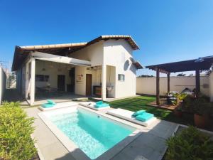 a backyard with a swimming pool and a house at Horizonte Azul in Búzios