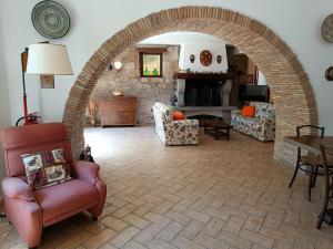 - un salon avec une arche, des chaises et une cheminée dans l'établissement Casale la Quercia - Splendido casale nella natura, à Cura