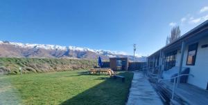 una casa con un cortile con tavolo da picnic e montagne di Penny's Drop Inn a Cromwell