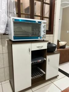 a microwave oven sitting on top of a cabinet at Vista Mar em PIÚMA in Itapitanga