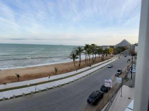 a view of a street and the ocean from a balcony at Vista Mar em PIÚMA in Itapitanga