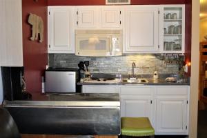 a kitchen with white cabinets and a sink and a microwave at Bear Canyon Condo #129 in Ruidoso +12 photos