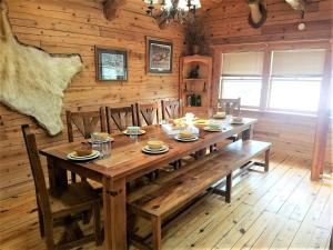 a wooden dining room with a wooden table and chairs at Bearadise in Ruidoso