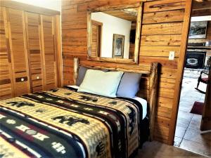 a bedroom with a bed and a mirror at Bearadise in Ruidoso