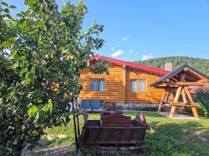 a log cabin with a bench in front of it at Cabana Alesia, relaxare la poalele Raraului in Câmpulung Moldovenesc