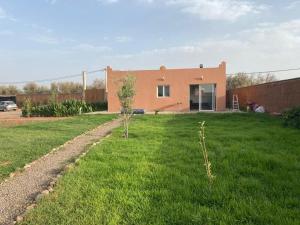 a house with a green yard in front of it at Sasa in Ech Chaïbat