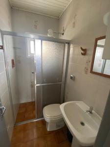 ein Badezimmer mit Dusche, Toilette und Waschbecken in der Unterkunft Casa Espaçosa e Confortável para Aluguel de Verão in Capão da Canoa