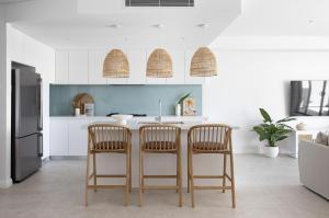 a kitchen with two bar stools and a refrigerator at Magenta Palms in Magenta