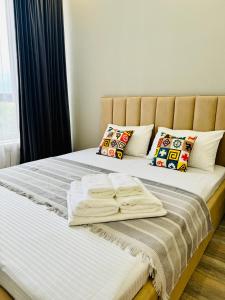 a bed with white sheets and pillows on it at Ethnic in Almaty