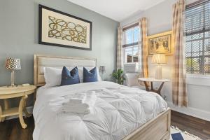 una camera da letto con un grande letto bianco con cuscini blu di Beautiful 1-BR Flat Nestled Between Dupont & Logan a Washington