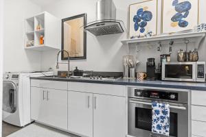 a kitchen with white cabinets and a stove top oven at Beautiful 1-BR Flat Nestled Between Dupont & Logan in Washington, D.C. +10 photos