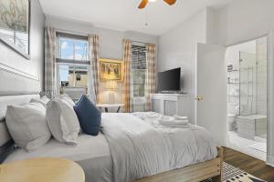 a bedroom with a bed with white sheets and blue pillows at Beautiful 1-BR Flat Nestled Between Dupont & Logan in Washington, D.C.