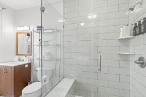 un bagno bianco con doccia e WC di Beautiful 1-BR Flat Nestled Between Dupont & Logan a Washington