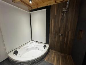 a bath tub in a bathroom with a shower at Cabaña Mazamitla Glamping de Altura in Mazamitla