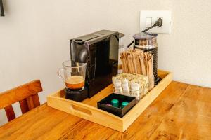 a coffee maker on a wooden table with a drink at JQY Beach Flats - 950m da Praia - Garagem subterrânea - Estação de carregamento para veículos elétricos in Juquei