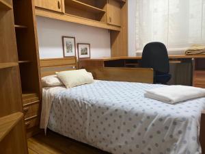 a bedroom with a bed and a desk and a chair at PISO ARTUR rúa astureses in Carballino