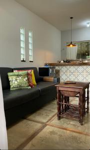 a living room with a black couch and a table at Espaço Villa Pella - Chalé Tulipa in Brumadinho