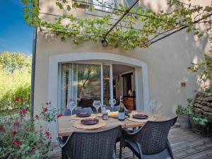 a wooden table and chairs on a patio at La grande Pinède in Faucon