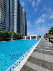 a swimming pool in front of some tall buildings at Casa D'Faiz Alanis near KLIA pool olympic size in Sepang