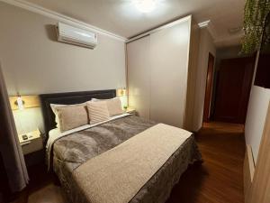 a bedroom with a bed and a air conditioner at 3 dormitórios ao lado da Rua Coberta in Gramado