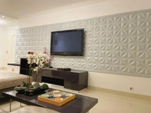 ein Wohnzimmer mit einem Flachbildfernseher an der Wand in der Unterkunft Appartement de 4pieces Gennevilliers in Gennevilliers + 5 Fotos