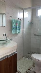 ein Bad mit einem Waschbecken und einer Dusche mit einem WC in der Unterkunft Suite Casal Mar e Lua em casa compartilhada in Ubatuba + 25 Fotos