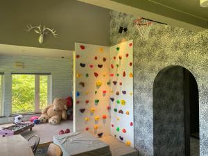 a room with a climbing wall and a stuffed bear at The BASE in Otaru +70 photos