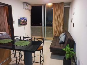 ein Wohnzimmer mit Tisch und Couch in der Unterkunft Condominio Berchatti Norte 1 in Vila El Carmen