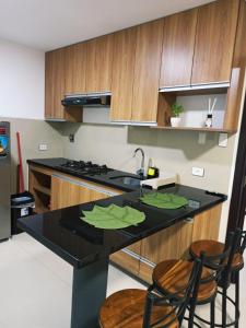 eine Küche mit schwarzer Arbeitsplatte und Holzschränken in der Unterkunft Condominio Berchatti Norte 1 in Vila El Carmen