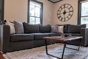 een woonkamer met een bank en een klok aan de muur bij Private Luxury Cottage Close to Downtown in St. Augustine +29 foto's