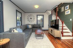 een woonkamer met een grijze bank en een televisie bij Private Luxury Cottage Close to Downtown in St. Augustine