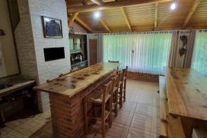 eine Küche mit einem langen Tisch und einigen Stühlen in der Unterkunft Casa de campo Campo Alegre SC 11 Hóspedes in Campo Alegre