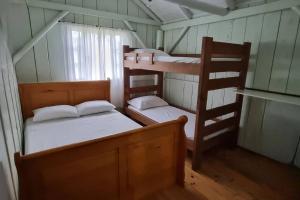 ein Zimmer mit zwei Etagenbetten und einer Leiter in der Unterkunft Casa de campo Campo Alegre SC 11 Hóspedes in Campo Alegre