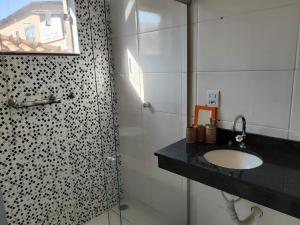 a bathroom with a sink and a shower at Casa espaçosa em frente à pracinha in Capitólio +13 photos